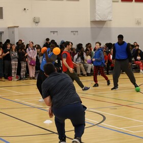 des élèves au gymnase dans un match de balles oranges