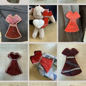 Épinglettes en forme de robes rouges confectionnées par les élèves